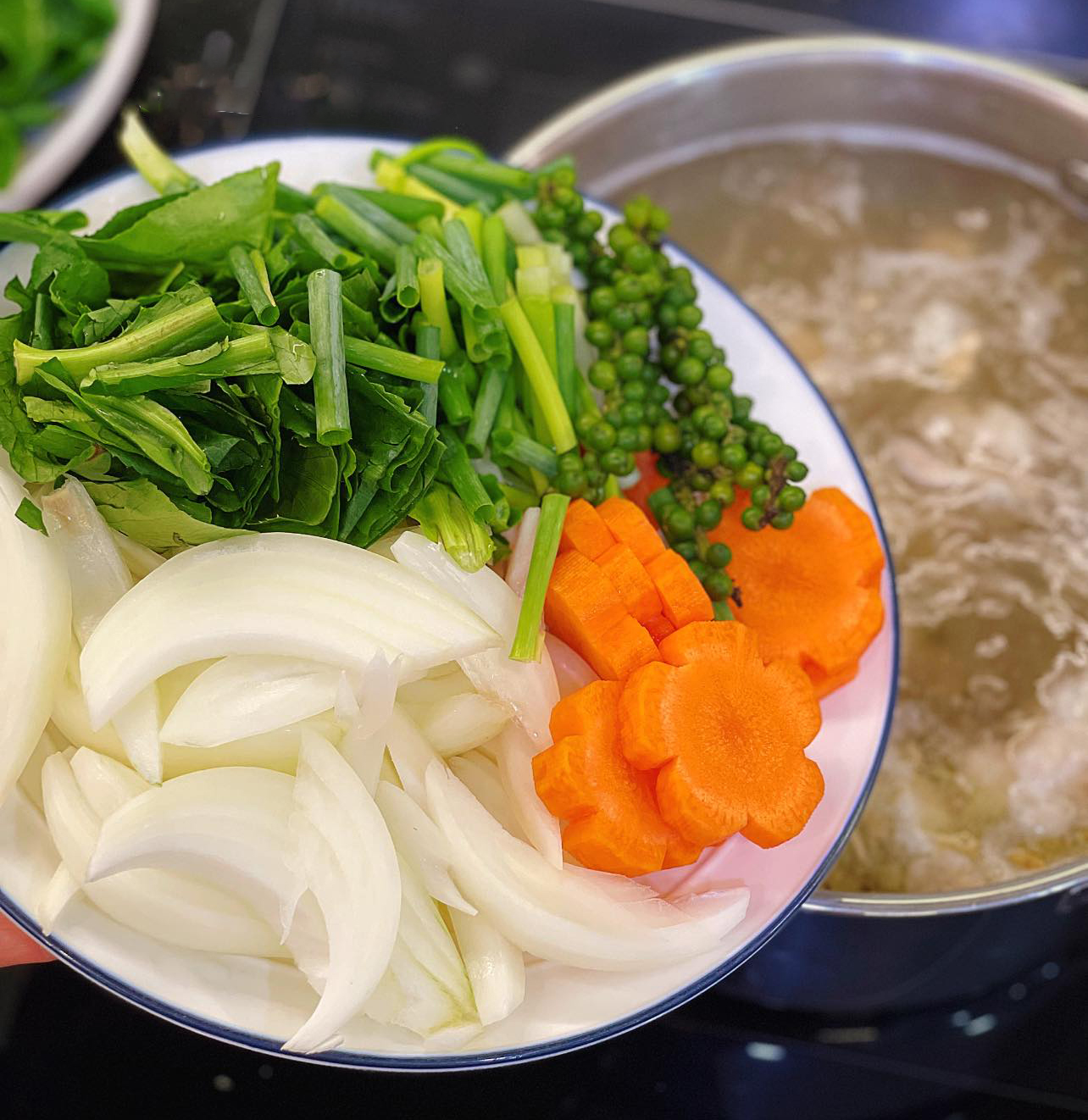 Cho thêm rau củ vào nồi lẩu